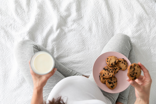 top-view-pregnant-woman-eating-chocolate-cookies